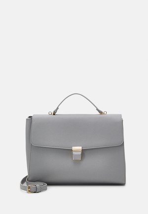 Sac à main gris structuré avec une poignée supérieure, fermeture à rabat, fermoir doré et une bandoulière détachable enroulée à côté.
