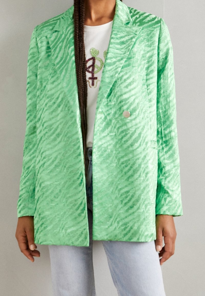 Blazer de estampado a rayas verde en tejido ligero y texturizado; presenta un collar con muesca y un cierre de un solo botón plateado.