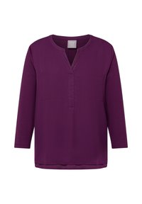 Lila langärmlige Bluse mit V-Ausschnitt, zwei Fronttaschen und glatter Textur. Schlichtes Design mit lockerem Schnitt.