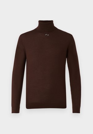 Rjav pulover s turtleneck ovratnikom iz mehkega materiala, z dolgimi rokavi in majhnim kovinskim dodatkom spredaj. Gladka tekstura, prilegajoč dizajn.