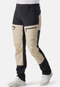 Tvåfärgade vandringsbyxor i svart och beige, med dragkedjefickor, elastisk midja och förstärkta knäsektioner för hållbarhet.