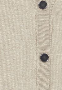 Cardigan in maglia beige con texture a coste, chiusura a bottoni con bottoni circolari scuri e una finitura in tessuto liscia.