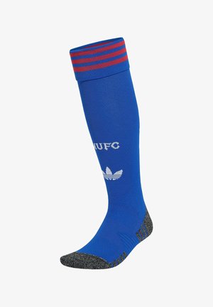 Niebieska, sięgająca do kolan sportowa skarpeta z czerwonymi paskami na ściągaczu, szarymi palcami i piętą, białym napisem "MUFC" oraz białym logo Adidas trefoil na łydce.