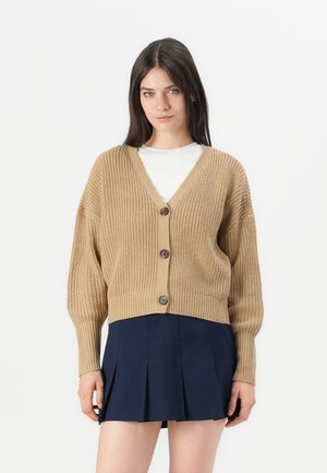 Beige stickad cardigan med v-ringning, långa ärmar och tre knappar fram. Har ribbad textur och kort design.
