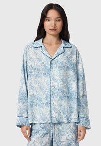 Paita ja hame sarja vaaleansinisellä ja valkoisella kaupunkikartta-kuvalla. Sisältää nappilukkoisen paidan, jossa on kaulus ja kontrastiväriset reunat.