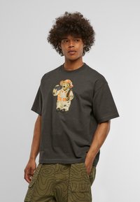 Tamsiai pilkas medvilninis marškinėliai su pieštuku nupieštu lokiu darbo drabužiais, įskaitant skrybėlę ir liemenę, su išskirtine iliustracija priekyje.