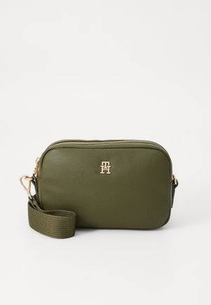 Sac bandoulière rectangulaire vert olive avec fermeture éclair dorée et logo, doté d'une large sangle en tissu réglable avec fermeture dorée.