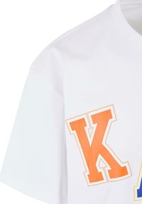 White cotton t-shirt with short sleeves, featuring large orange and blue graphic letters on the front. Smooth texture and crew neckline.