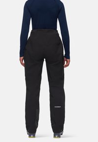 Μαύρα σκι παντελόνια με φερμουάρ στα πλάγια τσέπες, φτιαγμένα από ανθεκτικό ύφασμα, με ενισχυμένα κάτω μέρη ποδιών και κομψή ευθεία γραμμή.