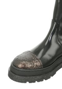 Black ankle boot with glossy finish, glittery brown toe cap, textured sole, and chunky black platform outsole.