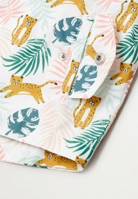 Vitt tyg med gula leoparder och gröna blad, med rosa och ljusgröna tropiska mönster. Inkluderar silverfärgade tryckknappdetaljer.