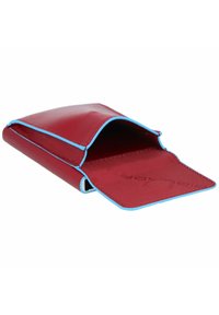Custodia per telefono in pelle rossa con cuciture a contrasto blu; design slim e leggermente curvo con parte superiore aperta e rivestimento interno morbido.