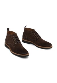 Botas de tobillo de ante marrón con puntera redonda, seis ojales, costuras en contraste y una lengüeta; exterior texturizado y suelas de goma.