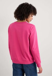 Fuchsia roze sweatshirt met een ronde hals, lange mouwen en ribbelzoom. Gemaakt van zachte stof, met een minimalistisch ontwerp zonder versieringen.
