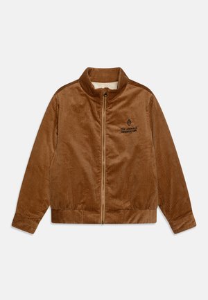 Brązowa kurtka z korduroju z wysokim kołnierzem, przednim zamkiem i ściągaczami. Posiada haftowane logo na lewej piersi.