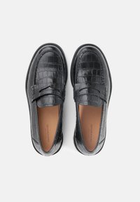 Μαύρα δερμάτινα μοκασίνια με σχέδιο κροκοδείλου, στρογγυλεμένη μύτη και επένδυση με μαξιλάρι. Λεία υφή και διακριτικές ραφές.