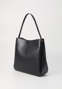 Black leather tote bag with a smooth texture, tapered shape, and a single shoulder strap. Features minimalistic design and no visible hardware.