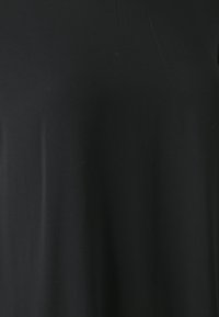 Black t-shirt made from smooth fabric, featuring a round neckline and short sleeves. Simple design with minimal texturing.