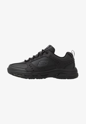 Scarpa sportiva nera con lacci, suola spessa, collo imbottito, linguetta sul tallone e logo "S" sul lato, vista profilo sinistro.
