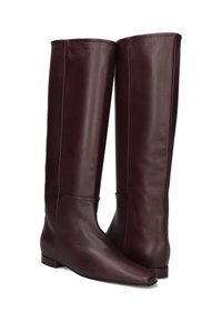 Bordeaux leren kniehoge laarzen met een gladde textuur, puntige neus, platte hak en minimale stikdetails.