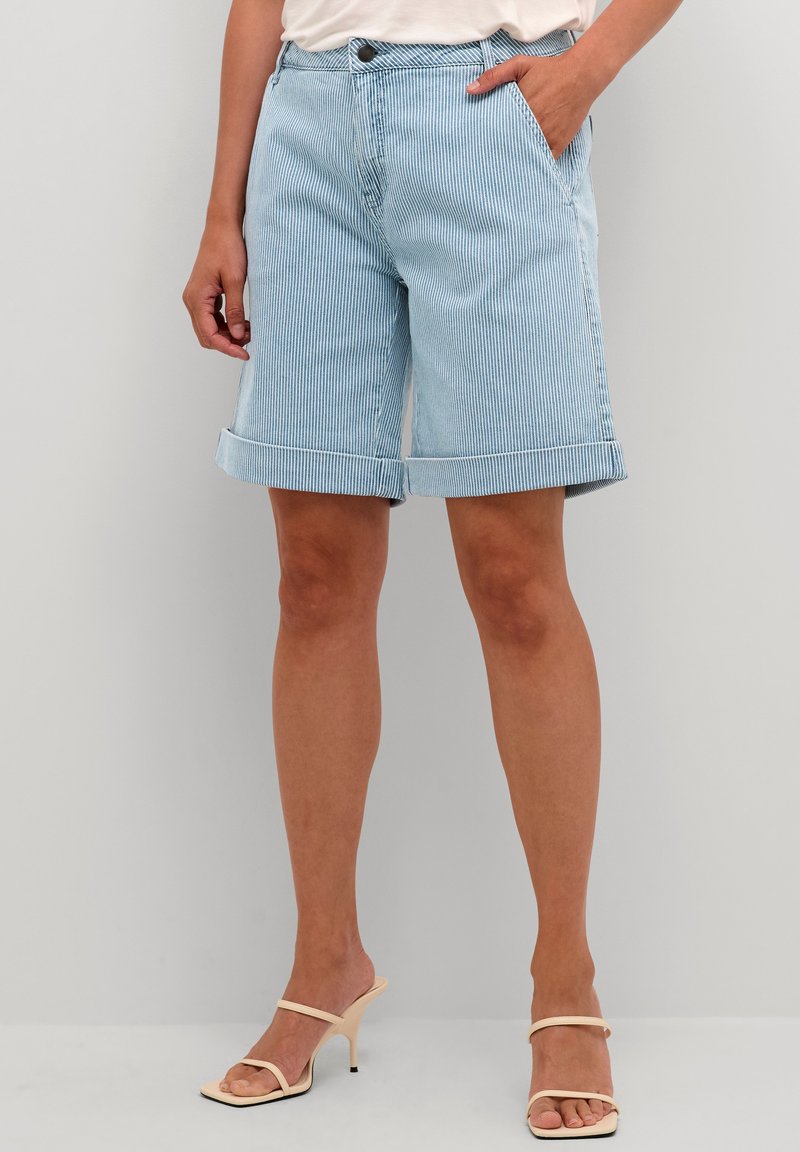 Shorts in denim azzurro chiaro con righe verticali bianche, con risvolti e tasche laterali, dotati di chiusura con bottone e zip in vita.