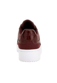 Sneaker bordeaux con tomaia texture, suola bianca e logo in rilievo sul tallone. Presenta una finitura liscia e una collana imbottita per il comfort.