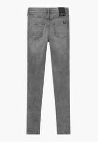 Harmaat kapeat farkut, joissa on sileä pinta, viisi taskua ja merkkilogo vyötäröllä. Hieman kulunut viimeistely.