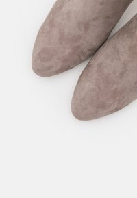 Szare zamszowe buty na szpilce z ostrym noskiem, o gładkiej fakturze, charakteryzujące się eleganckim designem oraz brakiem widocznych elementów metalowych i wzorów.