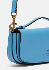 Niebieska skórzana torebka o zdefiniowanej konstrukcji, z złotymi elementami, cienkim paskiem i kontrastującym czarnym wykończeniem. Szczegół z wytłoczonym logo.