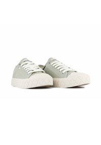 Sneakers in tela verde con lacci bianchi, suola in gomma bianca testurizzata, punta arrotondata e un sottile dettaglio del logo sulla linguetta.