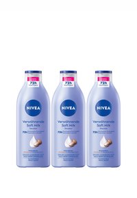 Drei NIVEA Verwöhnende Soft Milk Lotionflaschen mit 72h Feuchtigkeit und einer Abbildung von Sheabutter auf helllila Verpackung.