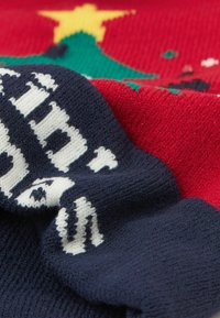 Sweter dziergany z czerwonym tułowiem, granatowymi rękawami z białymi literami oraz zielono-żółtym świątecznym wzorem. Miękka struktura z misternymi wzorami.