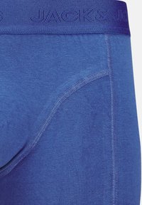 Blå boxershorts i ett mjukt, stretchigt tyg. Har en bred, texturerad midja prydd med "JACK & JONES". Slät, sömlös design.