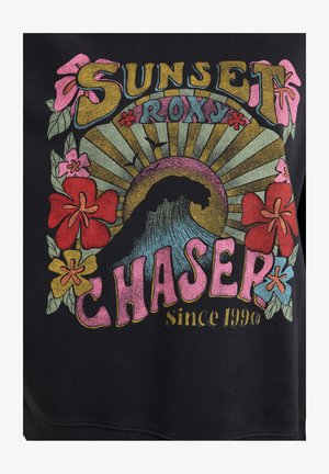 Sweatshirt noir avec un imprimé coloré représentant une vague, des fleurs et le texte "SUNSET ROXY CHASER depuis 1990." Le texte est en gras et de couleurs variées.