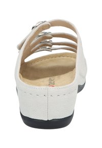 White leather sandal with an open back, multiple strap design, beige insole, and a black rubber sole. Features stitched detailing.