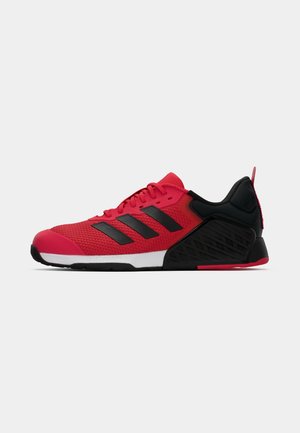Baskets de sport rouges avec des accents noirs, tige en maille, trois bandes noires, talon texturé noir et semelle intermédiaire blanche. Design léger pour le sport.