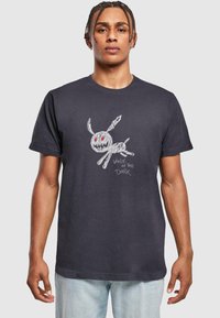 Mørkegrå bomulds t-shirt med et legende hvidt kaninmotiv med røde øjne og teksten "GÅ I MØRKET" i et afslappet skrifttype.