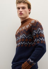 Strickpullover mit braunem und marineblauem Muster, geometrischen Designs, rundem Ausschnitt und strukturierter Oberfläche an den Ärmeln.