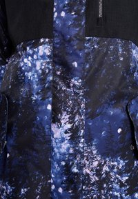 Wasserabweisende Jacke mit einem schwarzen oberen Abschnitt und einem blau-lila-schwarzen Waldmuster im unteren Abschnitt. Mit Reißverschluss und Taschen.