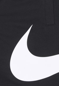 Czarna tkanina z wyraźnym, białym logo Nike Swoosh, gładka w dotyku i o minimalistycznym wzornictwie, bez dodatkowych wzorów czy detali.