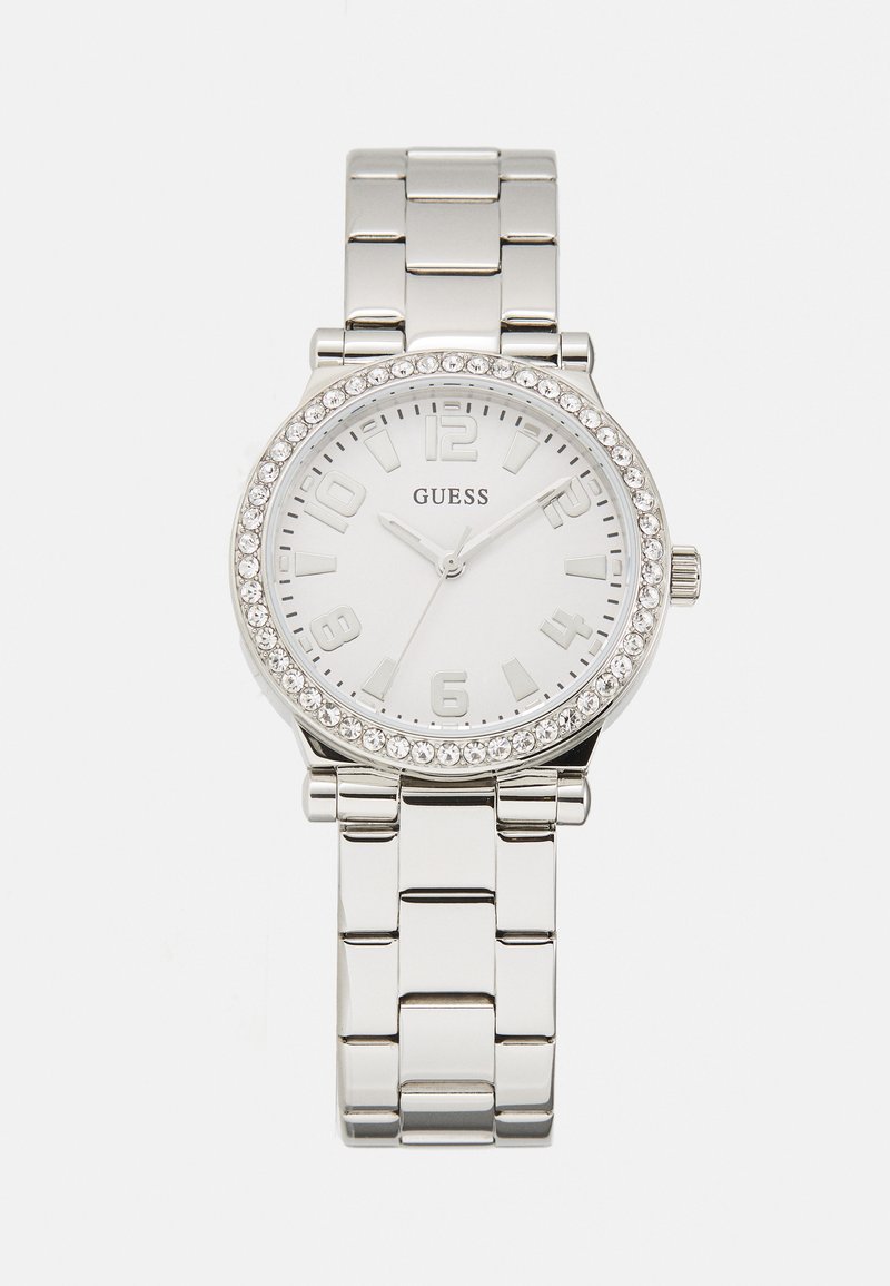 Strieborné kovové náramkové hodinky s bielym ciferníkom, luminescenčnými arabskými číslicami, kryštálovými akcentmi na lunete a náramkom z článkov.