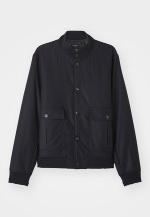 Navy blue jas van zacht materiaal, met een hoge kraag, voor een knoopsluiting, twee borstzakken en een geribde zoom en manchetten.