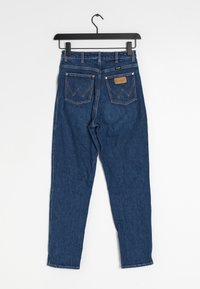 Mörkblå denimjeans med rak bendesign, med två bakfickor med ett zickzackmönster och en läderetikett i midjan.