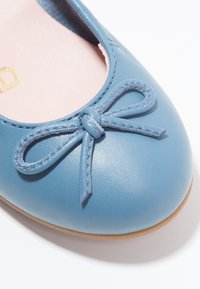 Hellblaue Leder-Ballerinas mit runder Zehenpartie. Mit einem passenden Schleifendetail an der Vorderseite und einer glatten Oberfläche sowie einer hellbraunen Sohle.