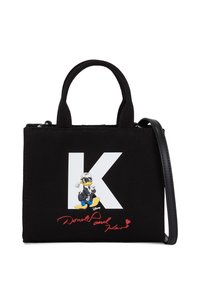 Schwarze Canvas-Handtasche mit einem weißen "K"-Grafik und einer Cartoonfigur. Besitzt kurze Griffe und einen abnehmbaren Schultergurt.