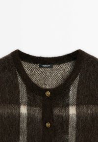 Brown checked cardigan in soft, fuzzy knit. Features a round neckline, gold buttons, and a contrasting light brown inner texture.