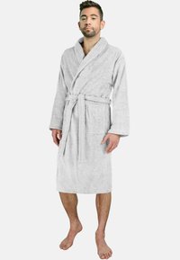 Gray, soft terry cloth bathrobe with long sleeves, belted waist, and a patch pocket. Model stands barefoot, showcasing robe length.