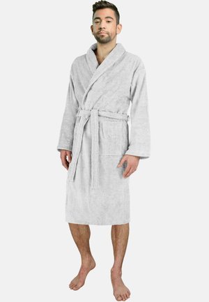 Grau, weicher Bademantel aus Frottier mit langen Ärmeln, Gürtel in der Taille und einer aufgesetzten Tasche. Das Model steht barfuß und zeigt die Länge des Bademantels.