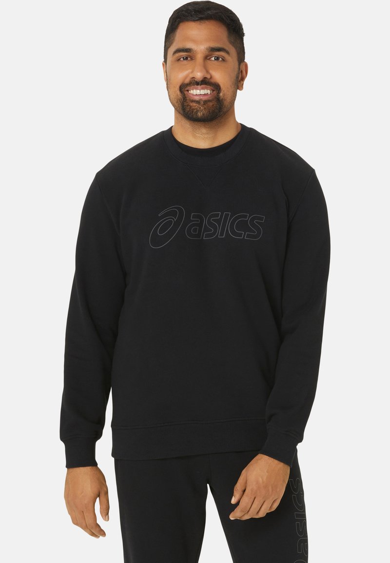 Sweatshirt noir à col rond, avec un logo texturé sur la poitrine. Le tissu semble doux avec des poignets et un ourlet côtelés.