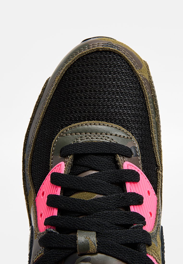 Baskets avec un dessus en mesh noir, des accents en suède olive, des détails roses sur la languette et des lacets noirs. Semelle extérieure en caoutchouc durable.